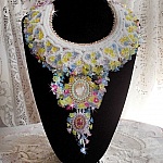 Plastron Envol&eacute;e Fleurie Haute Couture brod&eacute; avec des cabochons Nacre et R&eacute;sine aux couleurs Fuchsia et Ivoire, s&rsquo;ajoute des fleurs lucites, feuilles en verre, chatons et perles en Cristal.